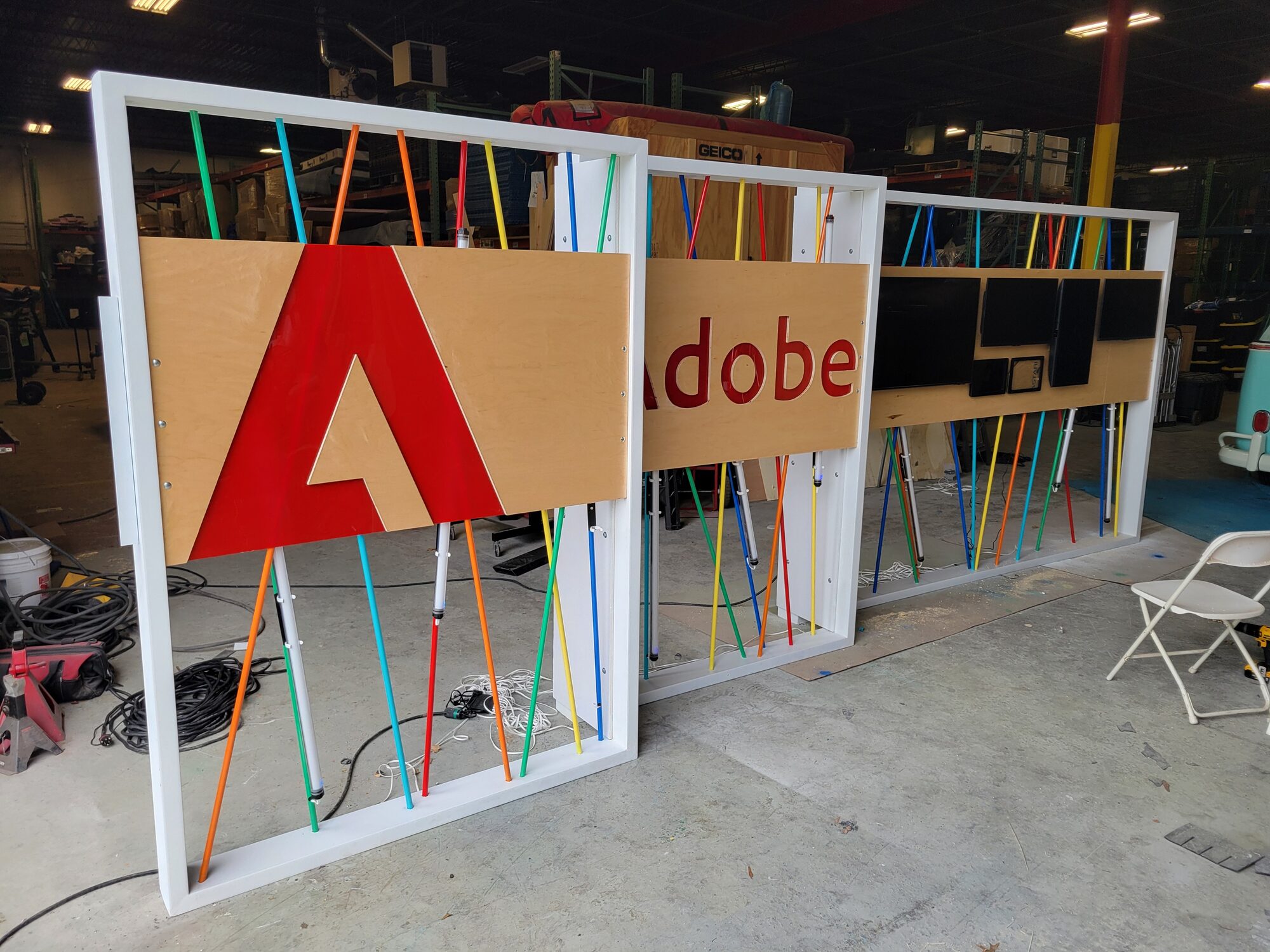 The full DELIVER wall panel mounted, monitors and tablets in place, shown alongside the CREATE and EDIT panels